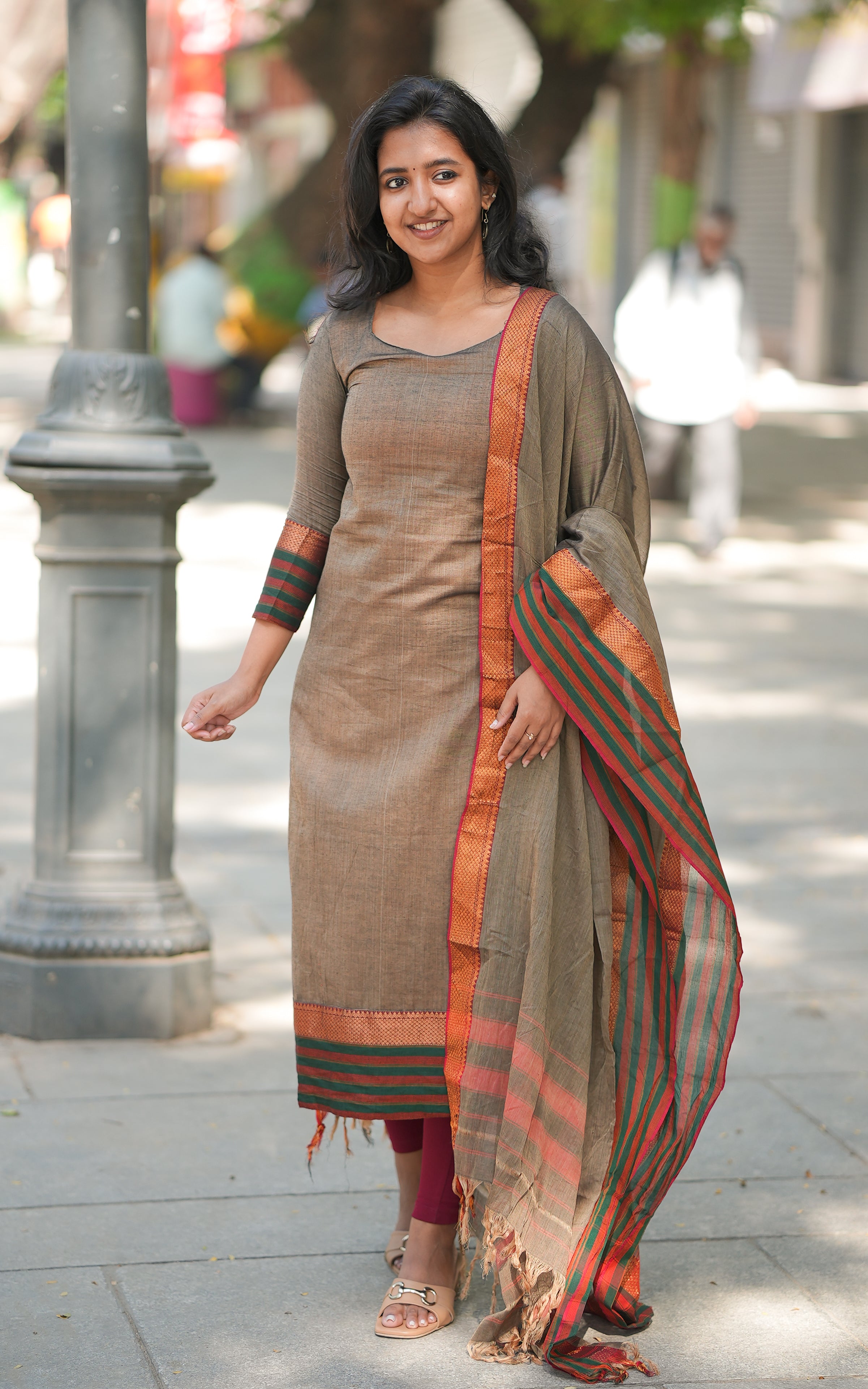A woman wearing a straight cut kurti with side slits and dupatta .
