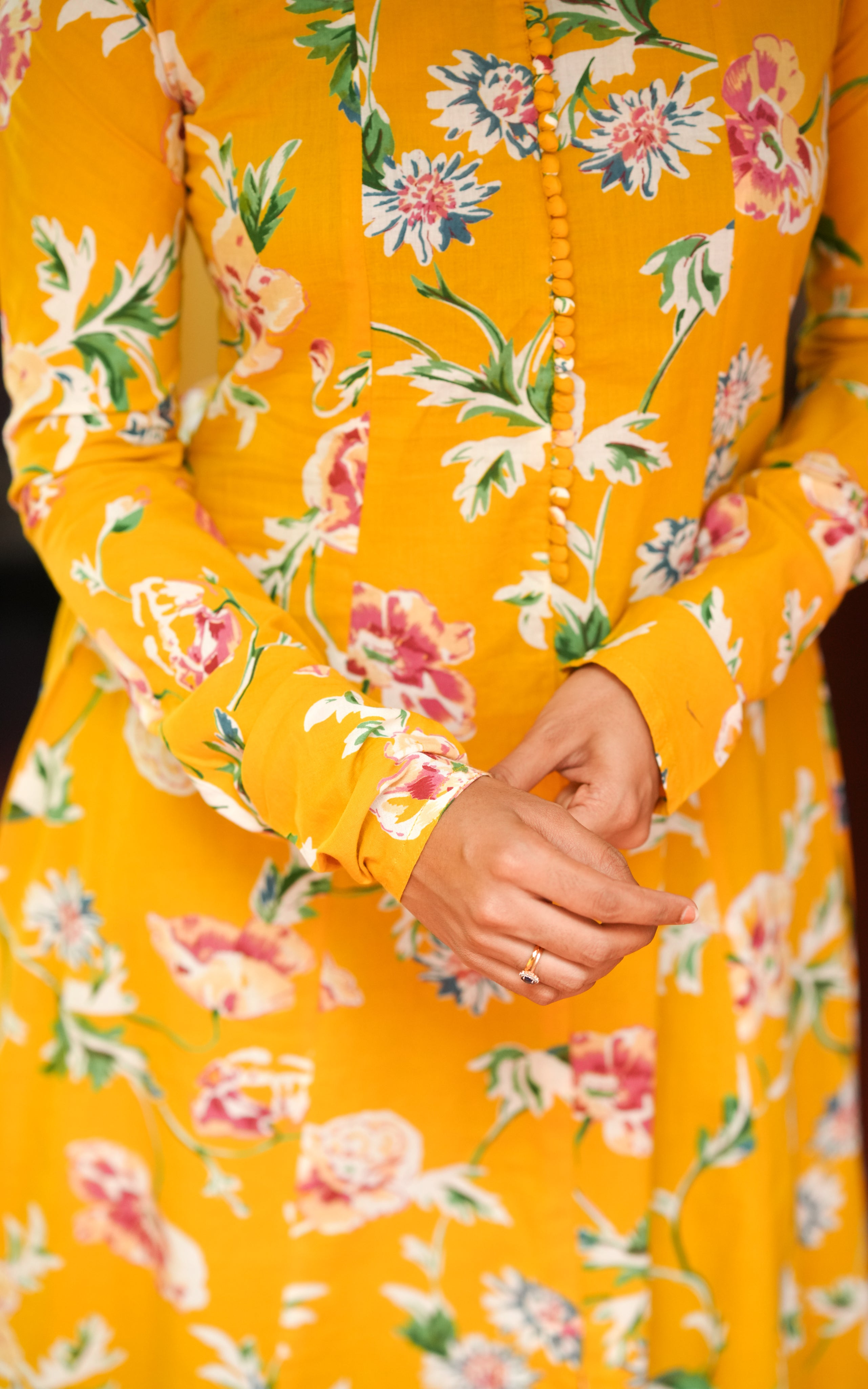 Woman wearing a bright yellow A-line cotton kurti.