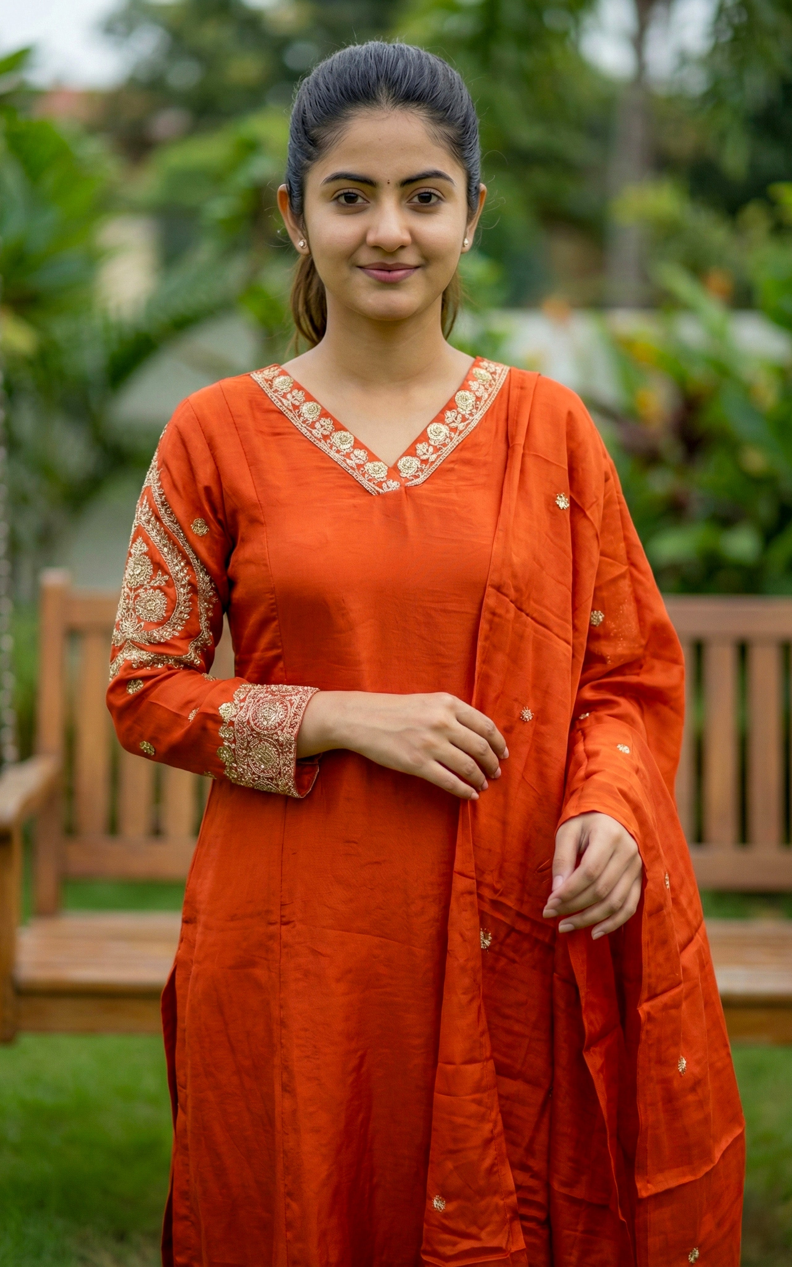 Woman wearing an orange traditional outfit with floral patterns