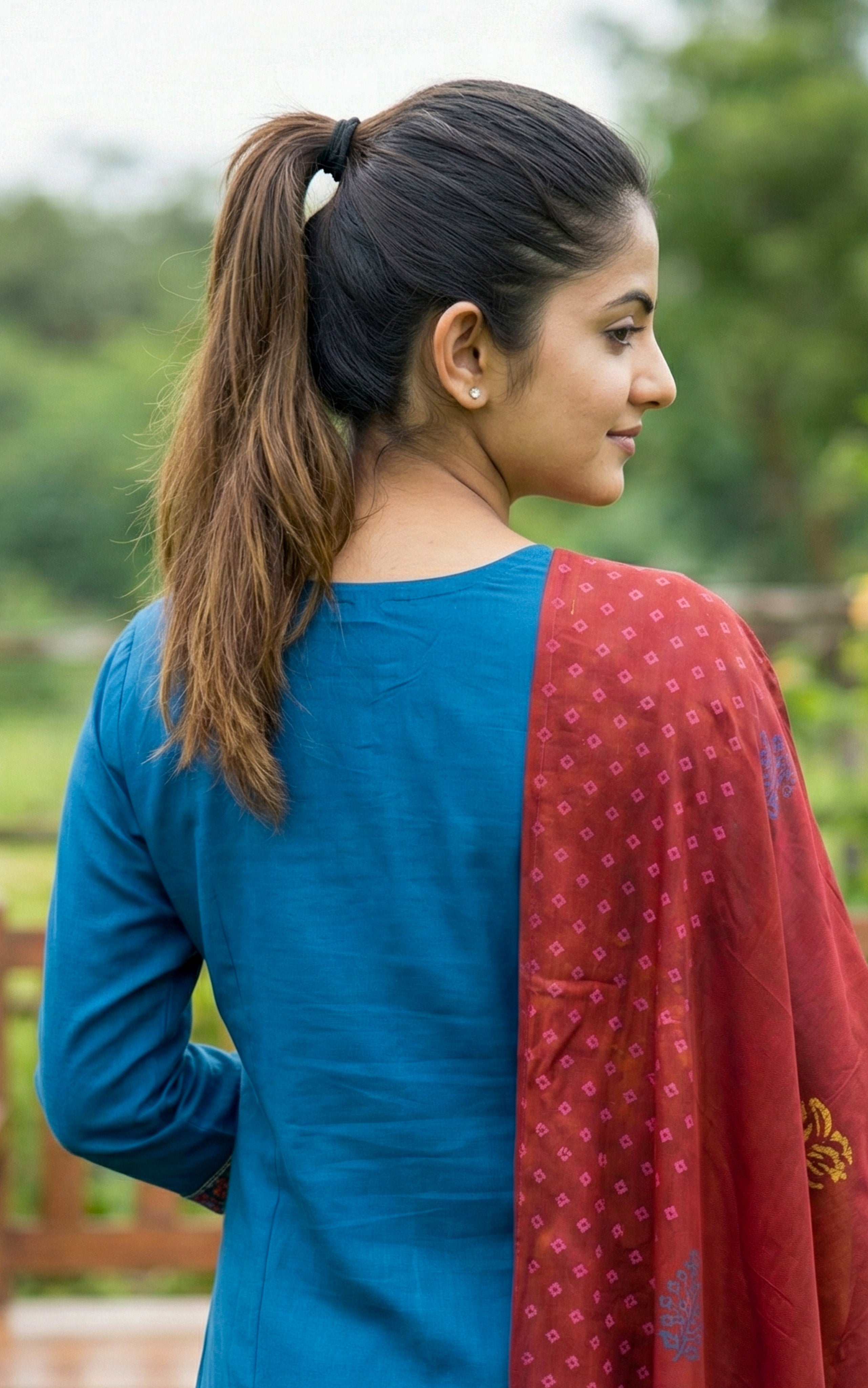 Woman wearing a blue top and red shawl