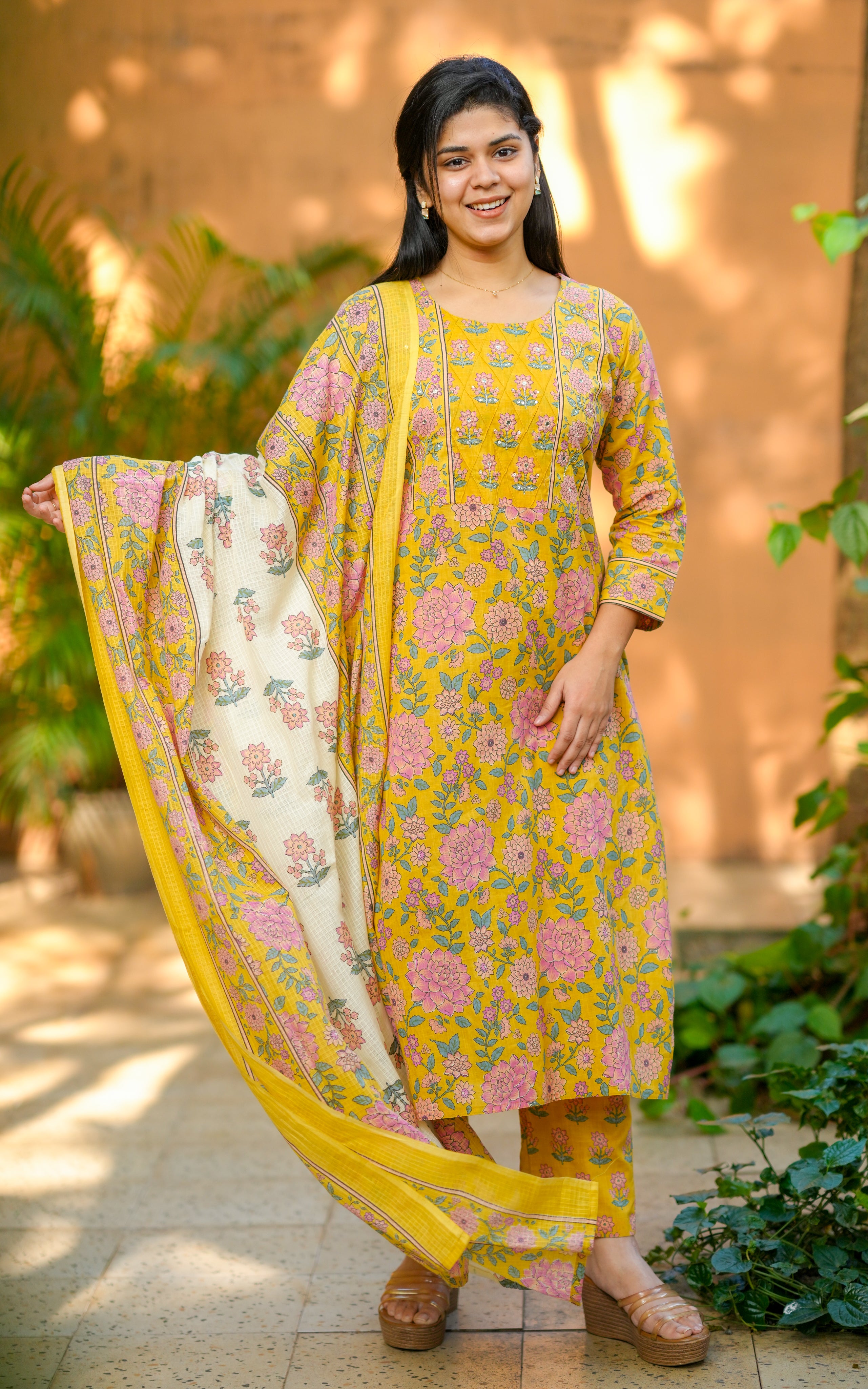 Woman wearing a yellow and pink traditional outfit with a dupatta