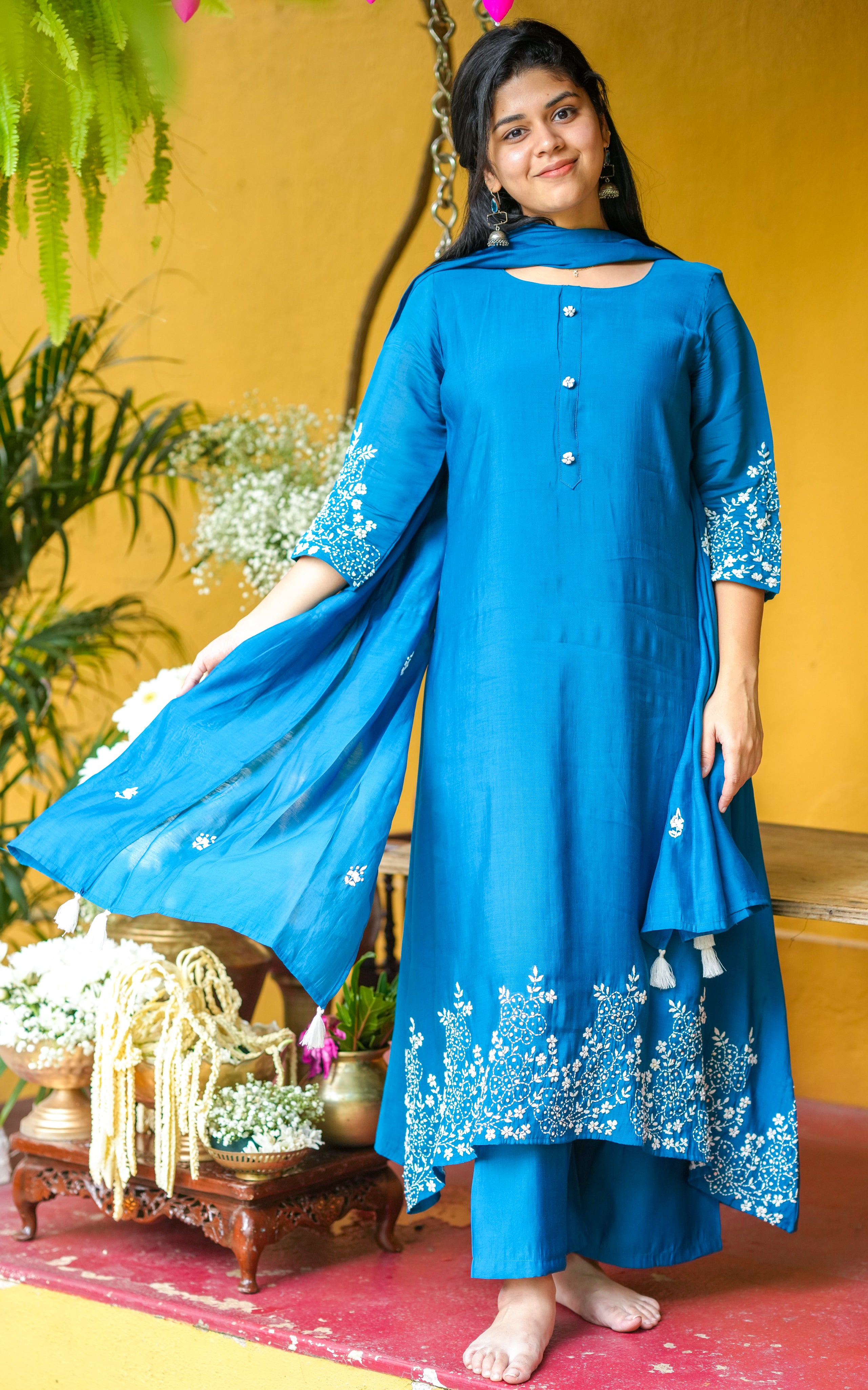 Woman wearing a blue traditional outfit with floral embroidery
