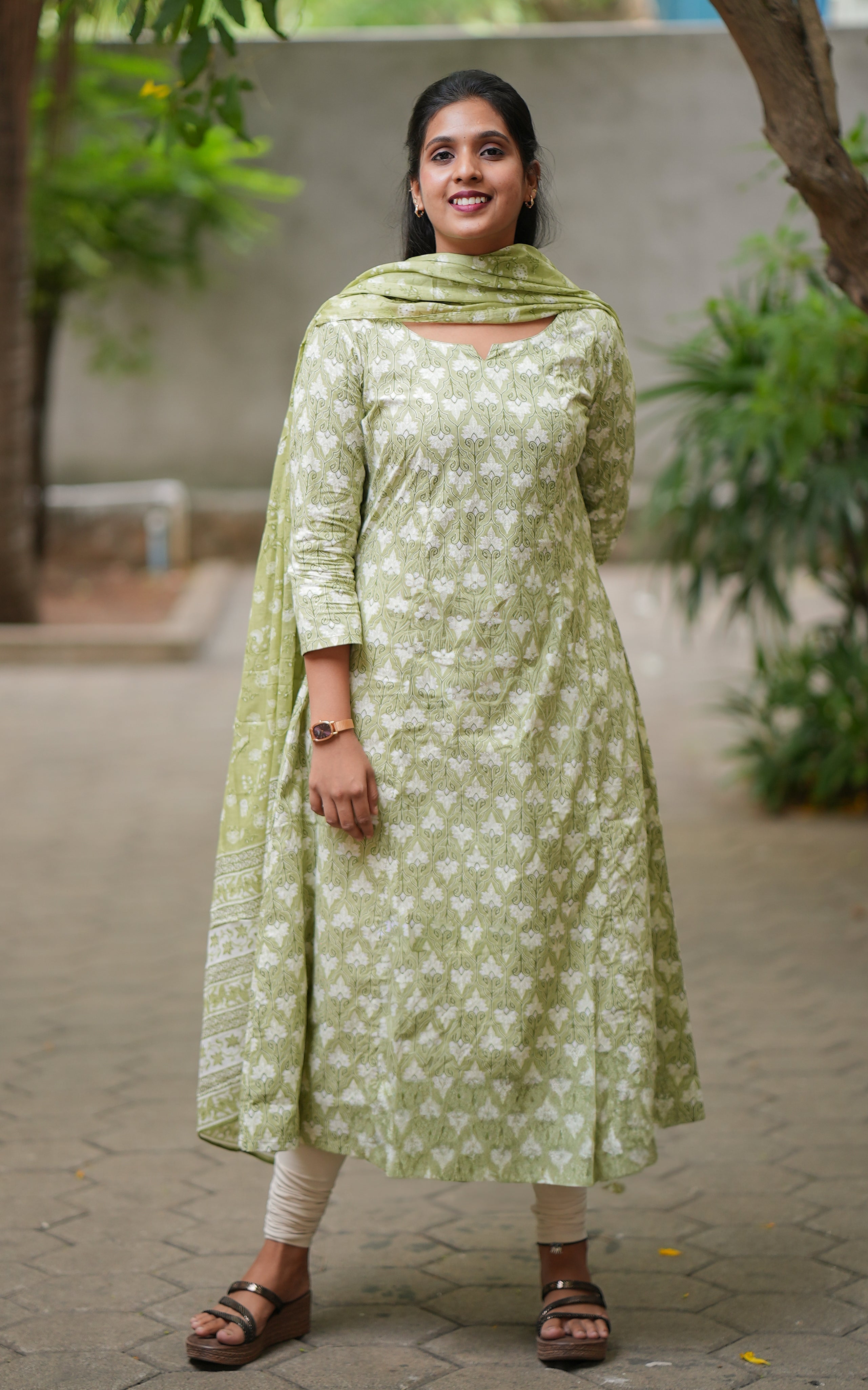 Woman wearing a green floral dress .
