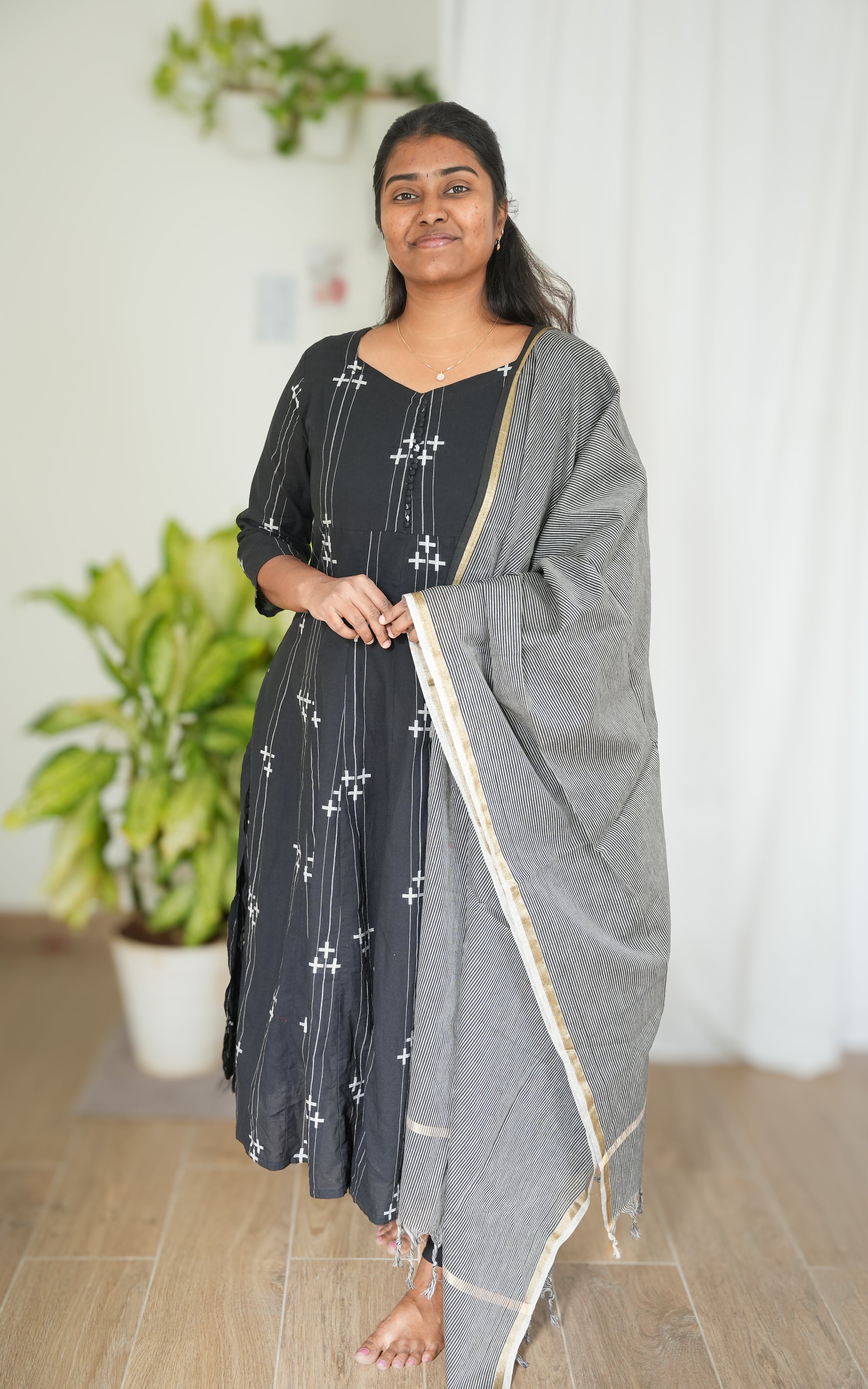 Black South Cotton A-line kurti with side slit, featuring a sweetheart neckline in front, round back neck with elegant potli buttons, paired with a grey handloom dupatta with golden border