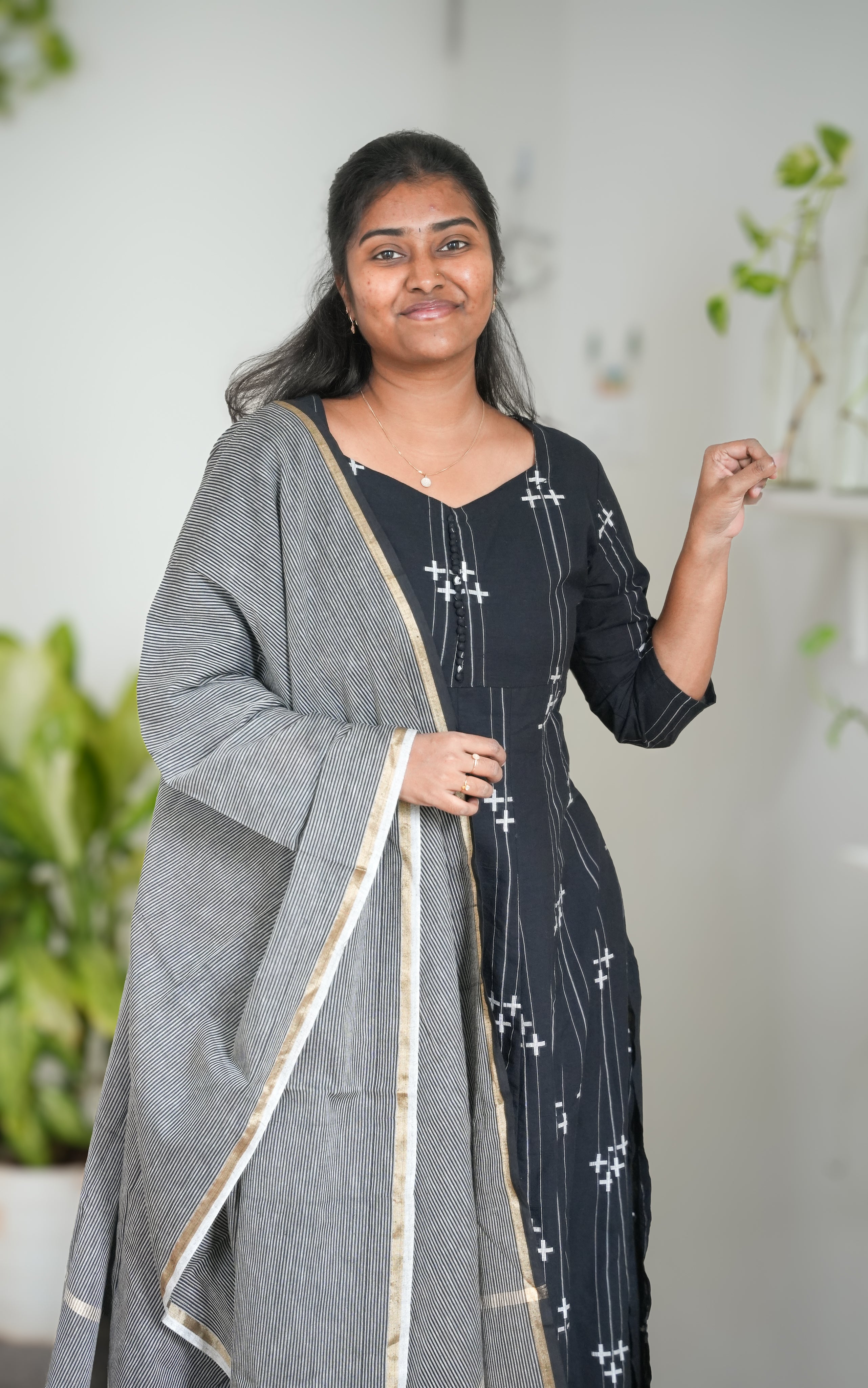 Elegant black A-line kurti in South Cotton with side slit, showcasing a front sweetheart neck design and round back neck accented with decorative potli buttons, matched with grey handloom dupatta with golden border