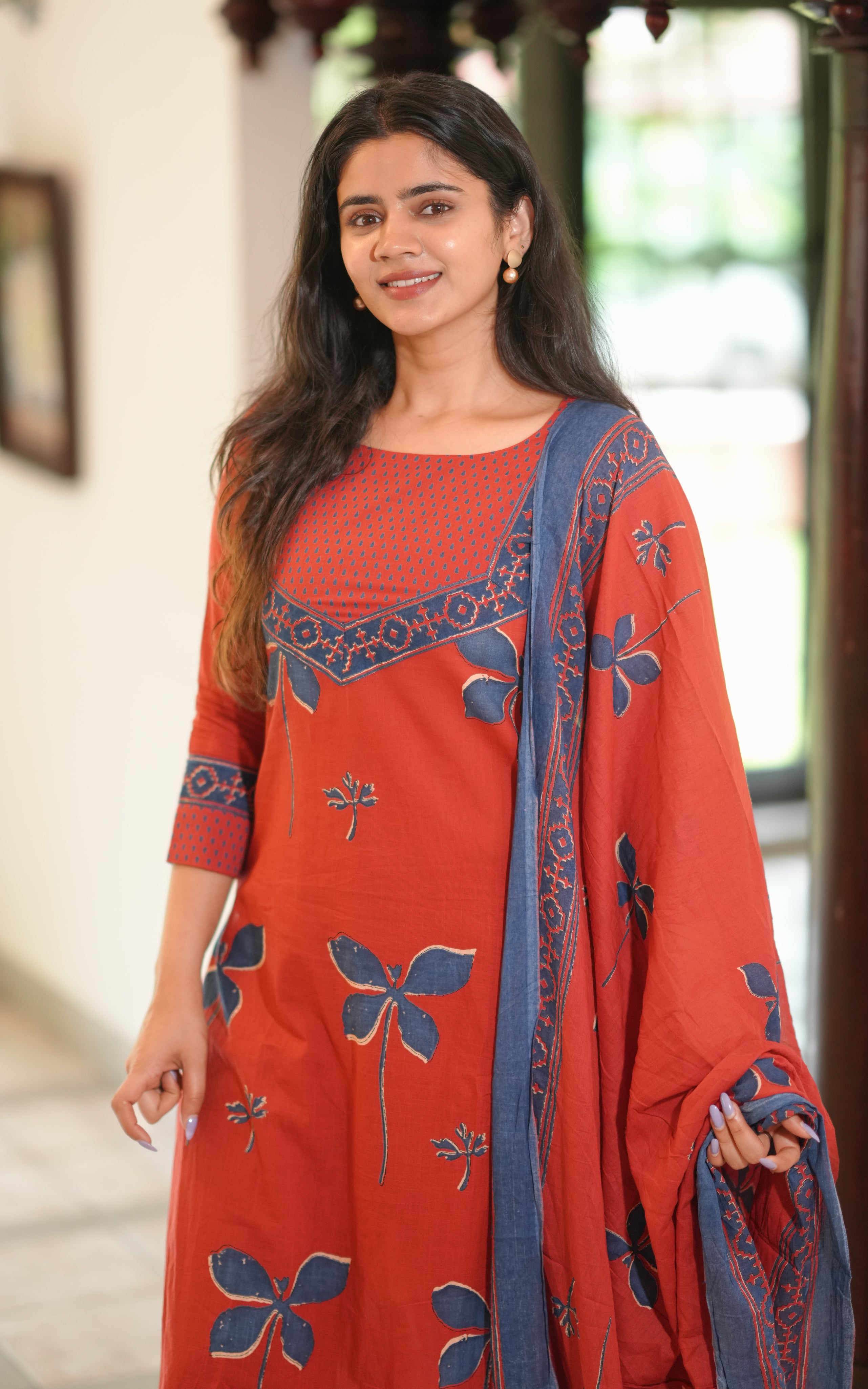 Woman wearing a maroon hand block printed straight cut kurti.