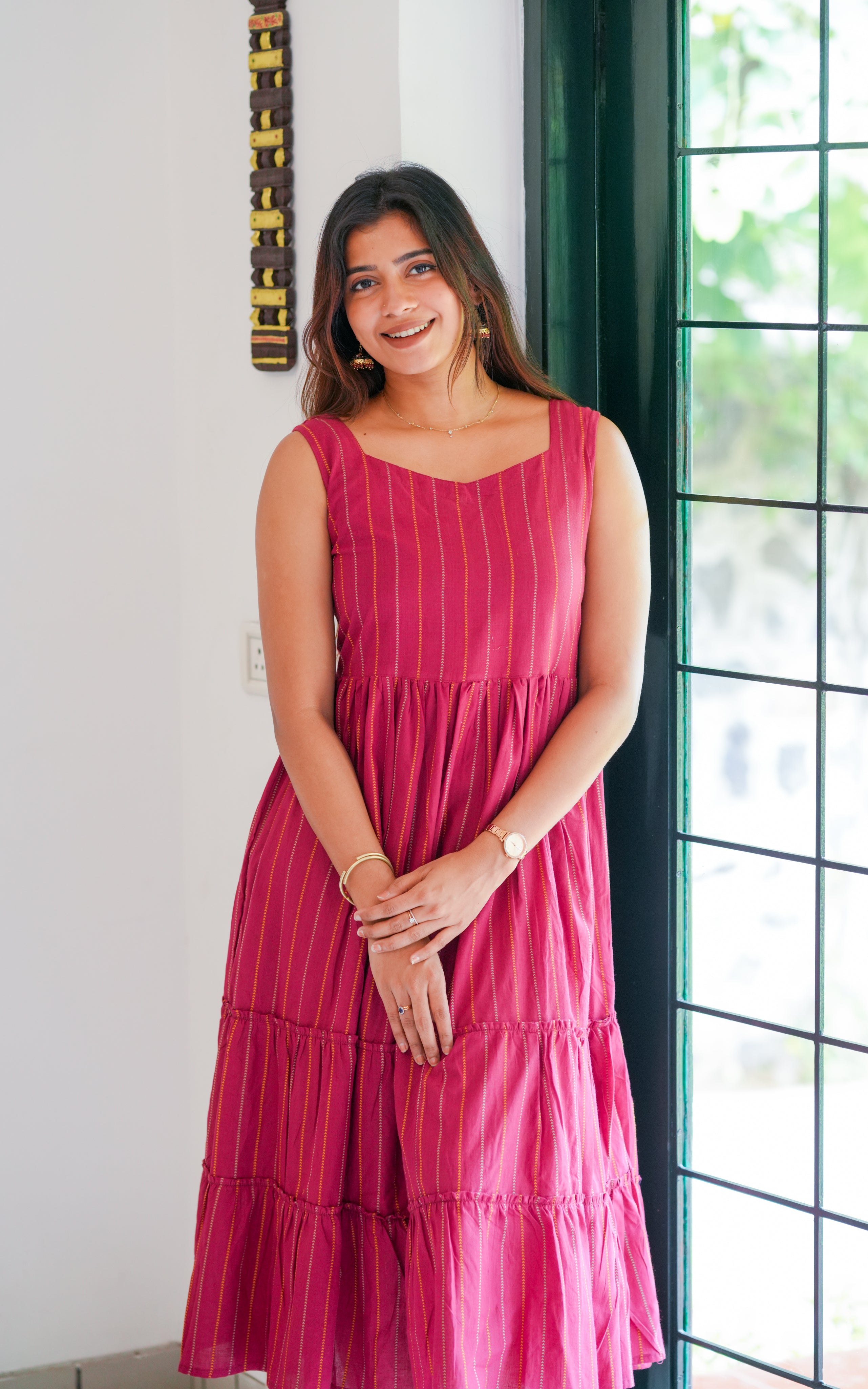 The frock features vertical golden and orange stripes that add a festive touch.