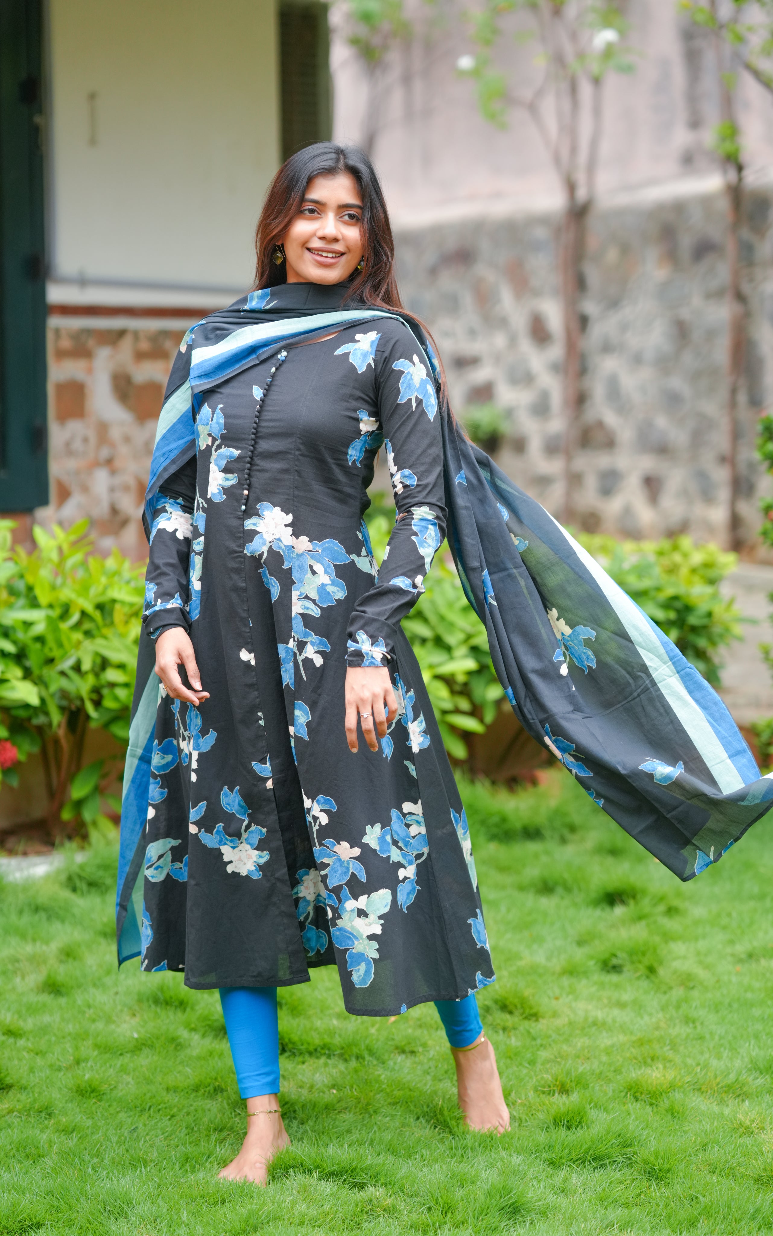 Woman wearing a black cotton A-line kurti with floral print.