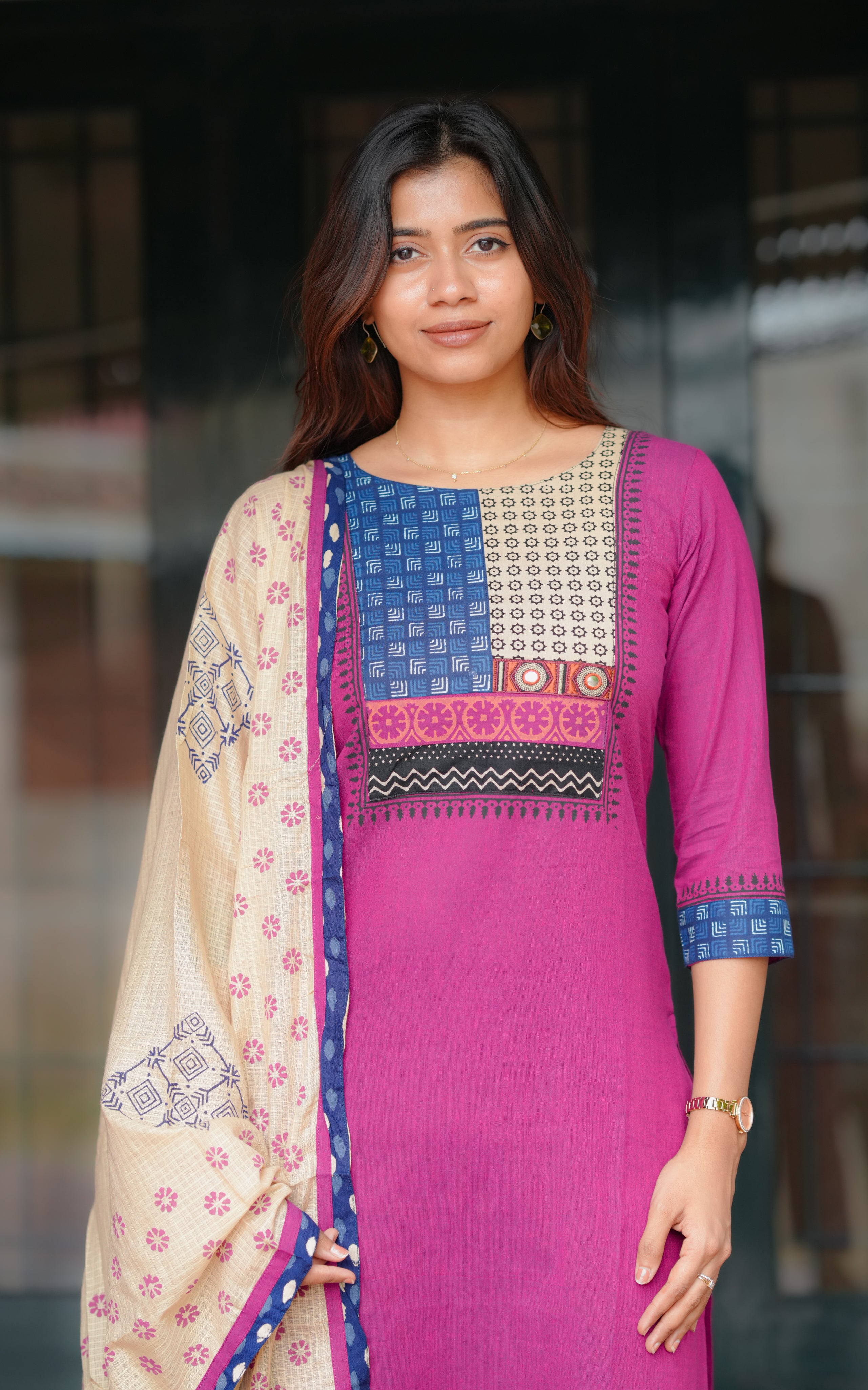 A woman is wearing a purple straight-cut kurti paired with matching pants.