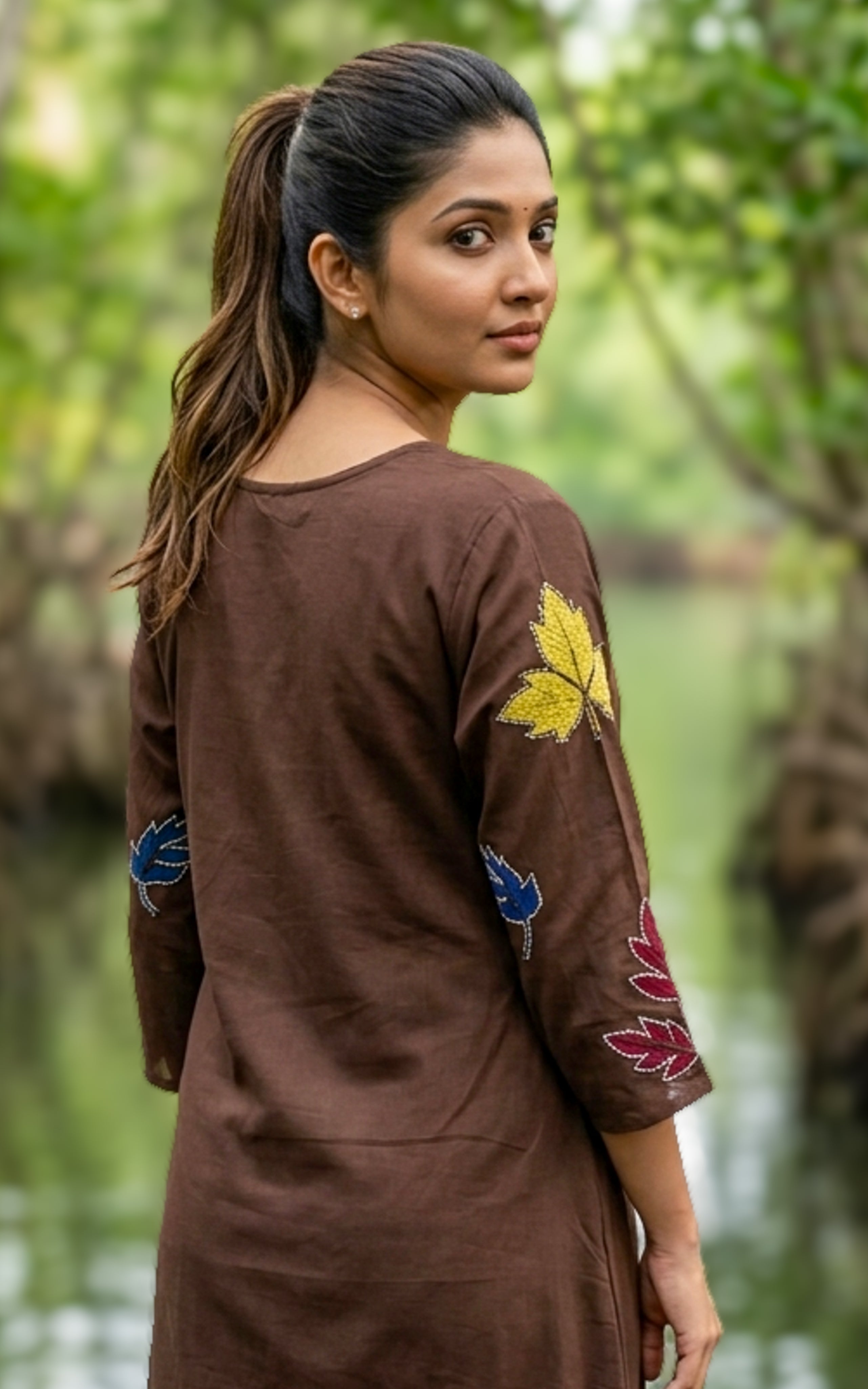 Woman wearing a brown dress with colorful embroidery 